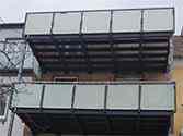 Balkong med stödstruktur av stålprofiler och glasräcke