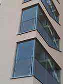 Yttre väggar tillverkad av säkerhetsglas i trapphuset. Glaspaneler monterad på stålram med hjälp av fixpoints i rostfritt stål