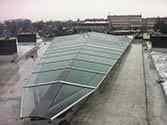Glastak med bärande stålkonstruktion på taket av ett bostadshus för att täcka en innergård öppning