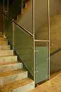 Glasräcke med runda rostfria satinbehandlad stolpar och handledare monterad på trappor