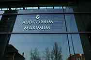 Rostfritt stål logotyp av Auditorium Maximum på en glas skiljevägg