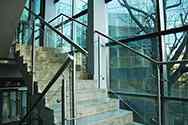 Glasräcke med rostfria satinbehandlad stolpar och handledare monterad på trappor