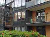 Balkongräcke av stål med fyllning av glas och fransk balkong glasräcke monterad på fasaden